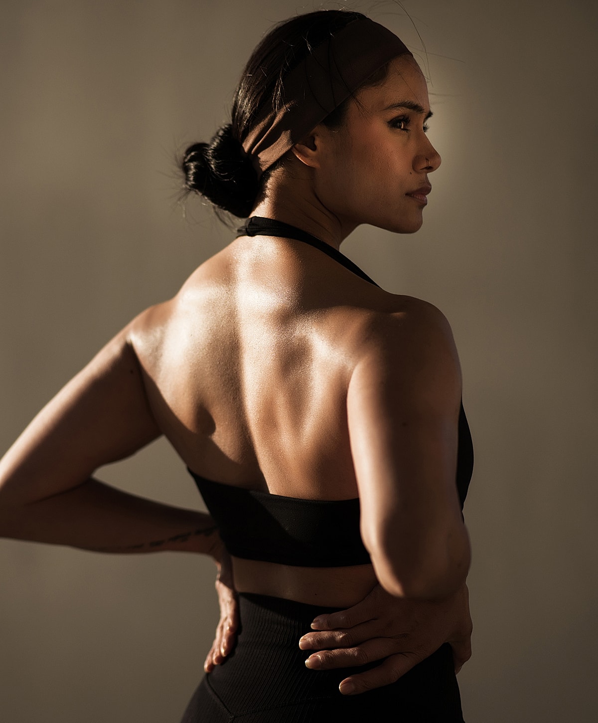 Person showcasing athletic physique in soft lighting.