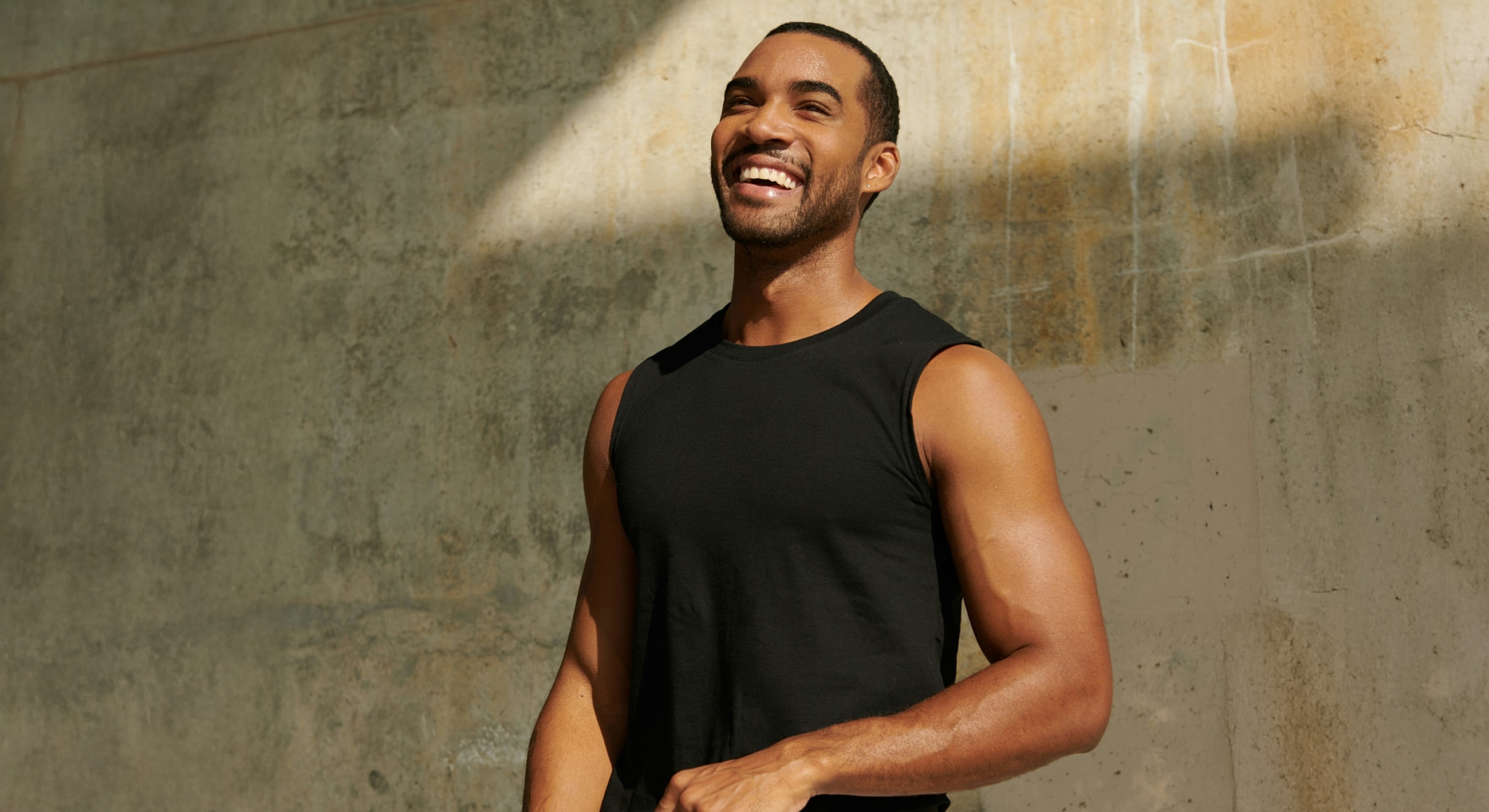 Gainesville, FL male tummy tuck model in a sleeveless black shirt.