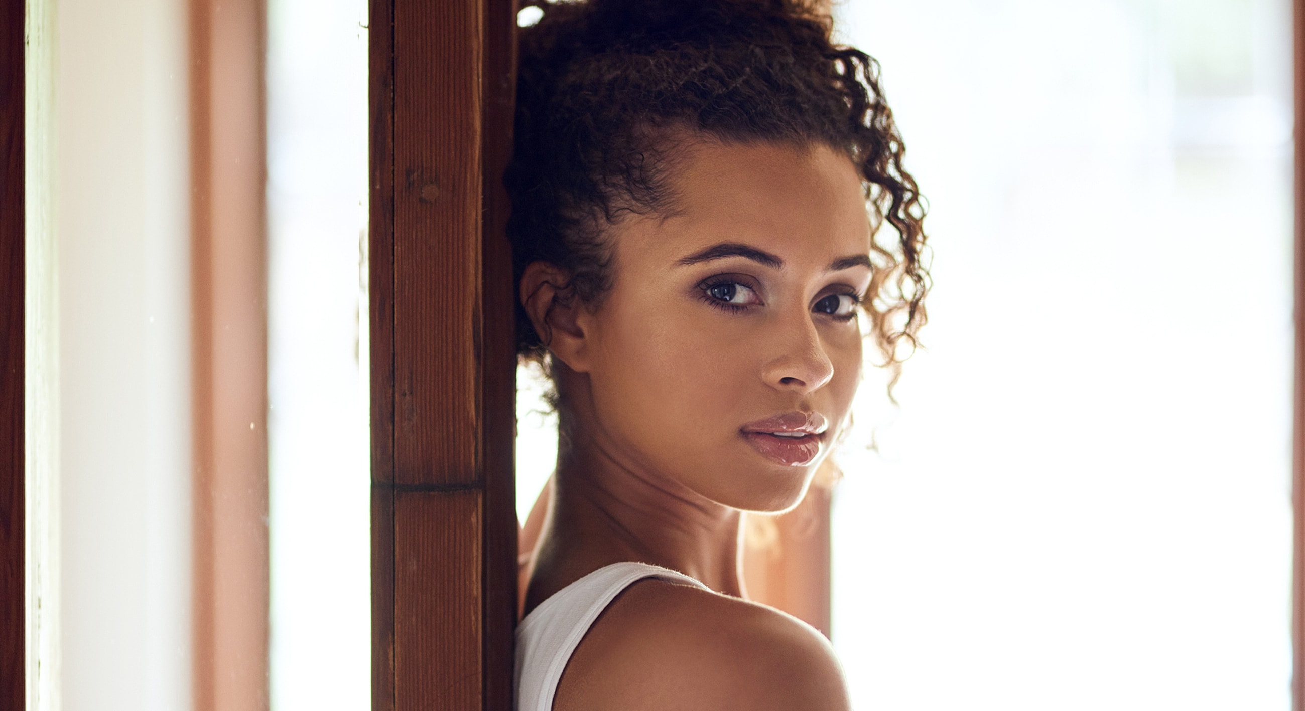 Gainesville, FL Radiesse model with curly hair, natural lighting portrait.