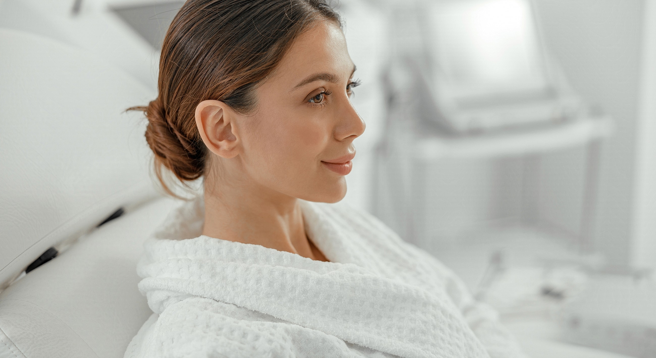 Woman in robe relaxing in spa setting.